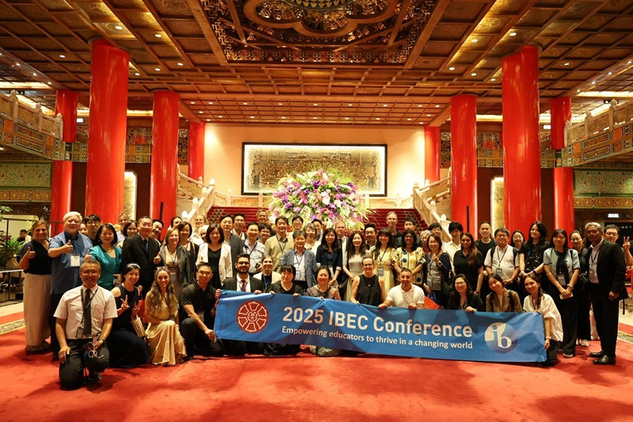 Personnes participant à la conférence de l’IBEC réunies pour une photo dans le hall du Grand Hotel, et tenant la bannière annonçant la conférence de l’IBEC 2025